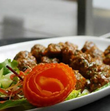 The Tandoor & Grill Restaurant located onsite at the Stanford Fernie Resort serves classic dishes such as lamb rogan josh with greens and tomato garnish.