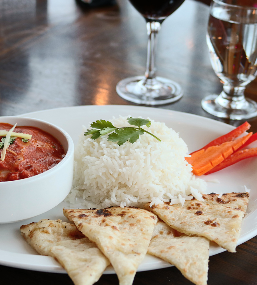 The Tandoor & Grill Restaurant at the Stanford Fernie Resort serves a plate of white rice topped with parsley, triangular shaped dosas, a bowl of dipping sauce and carrot and red pepper garnishes.